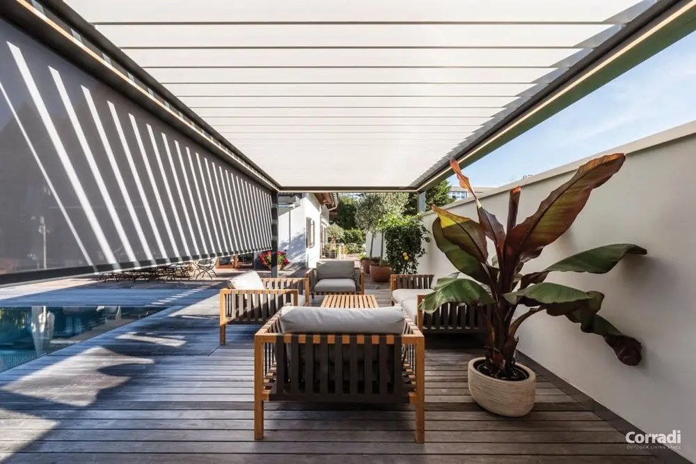 Imago® Pergola Bioclimatica addossata alla parete con tenda a rullo laterale